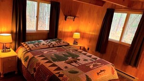 Una habitación acogedora con una cama, dos lámparas de noche y una ventana con cortinas.