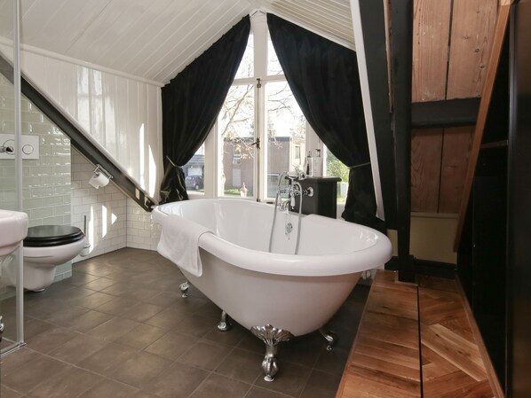 A bathroom with a freestanding bathtub, a toilet, and a sink.