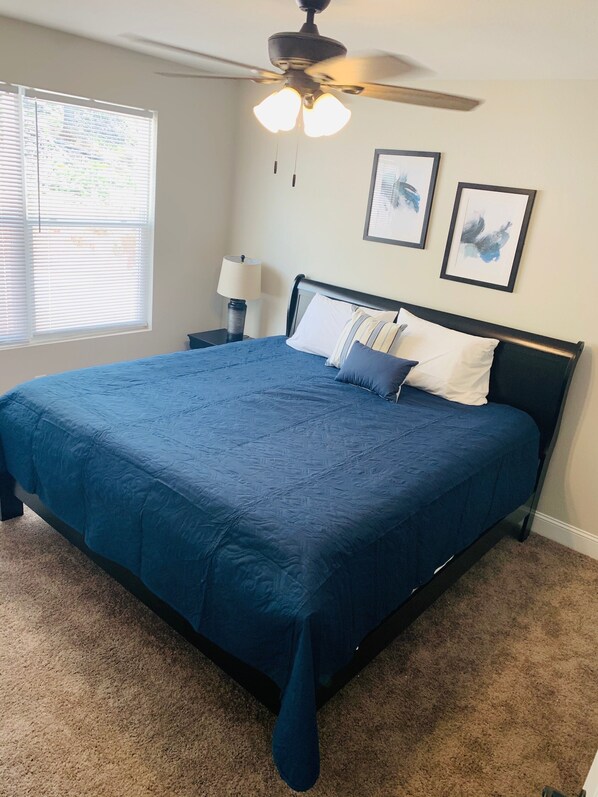 A bedroom with a large bed, a ceiling fan, a nightstand, a lamp, and two framed pictures on the wall. - Breathtaking 6Bd/6 Bath/PRIVATE DOCK All The Bells and Whistles! (La Follette)