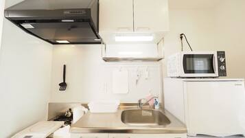 Kylskåp, mikrovågsugn, spishäll och grytor/köksredskap