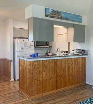 Kitchen features a central island, appliances, and a sink with a faucet.