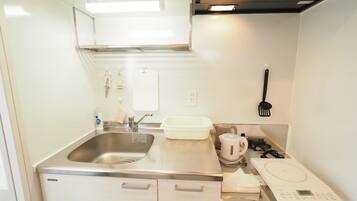 Kylskåp, mikrovågsugn, spishäll och grytor/köksredskap