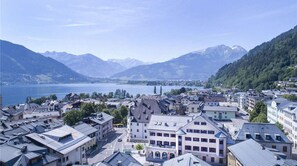 A town with buildings along a waterfront, surrounded by mountains and a lake.