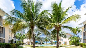 Un resort con piscina, palmeras y cielo despejado.