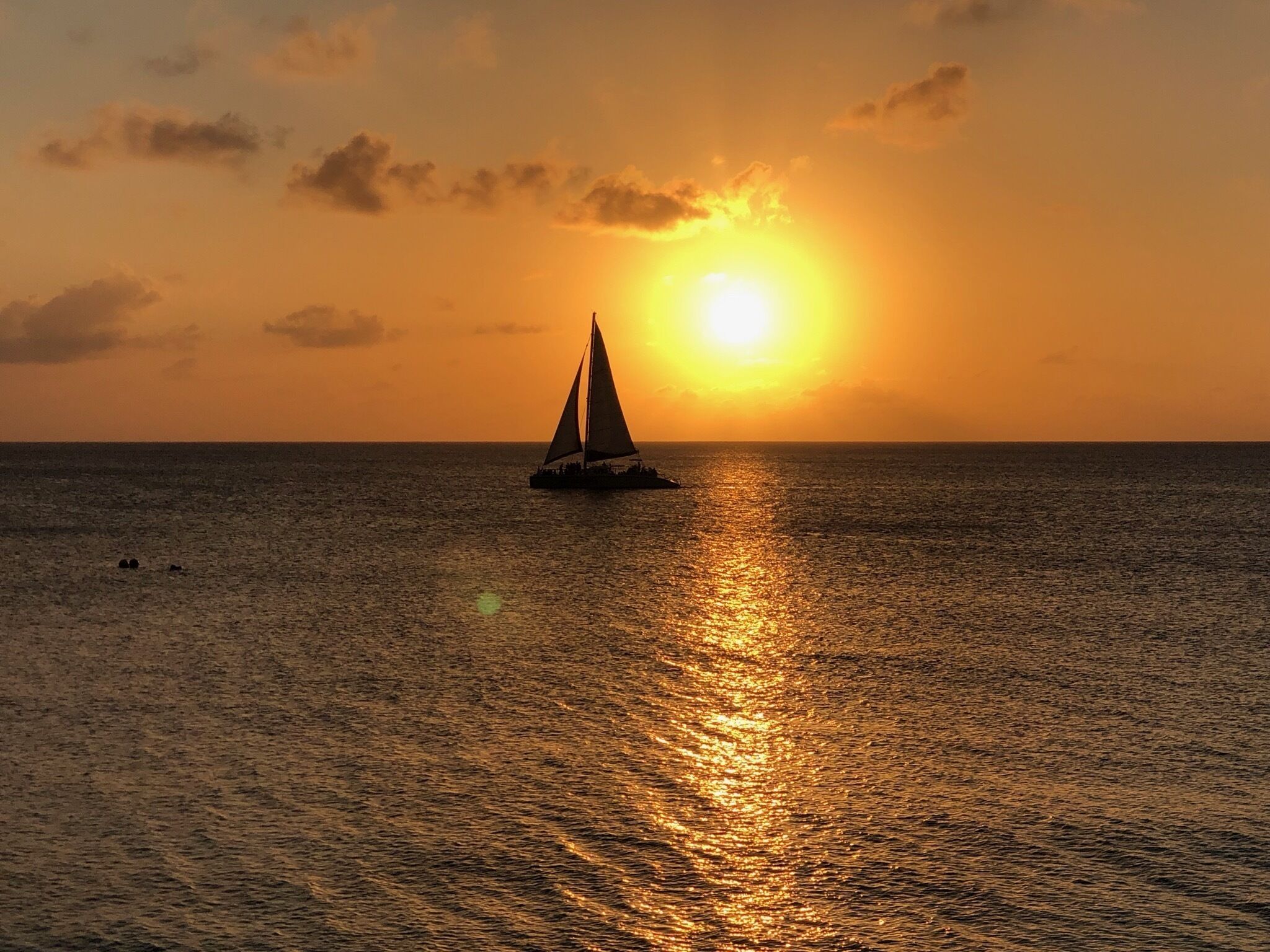 Un velero sobre aguas tranquilas al atardecer.