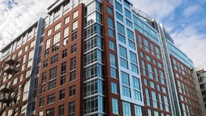 A multi-story building with a modern architectural design, featuring a mix of brick and glass facades. - National at Reston Town Center (Reston)