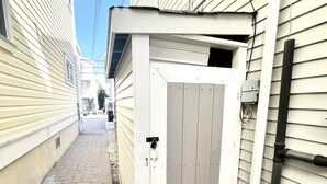 Een smalle steeg met een klein tuinhuisje.