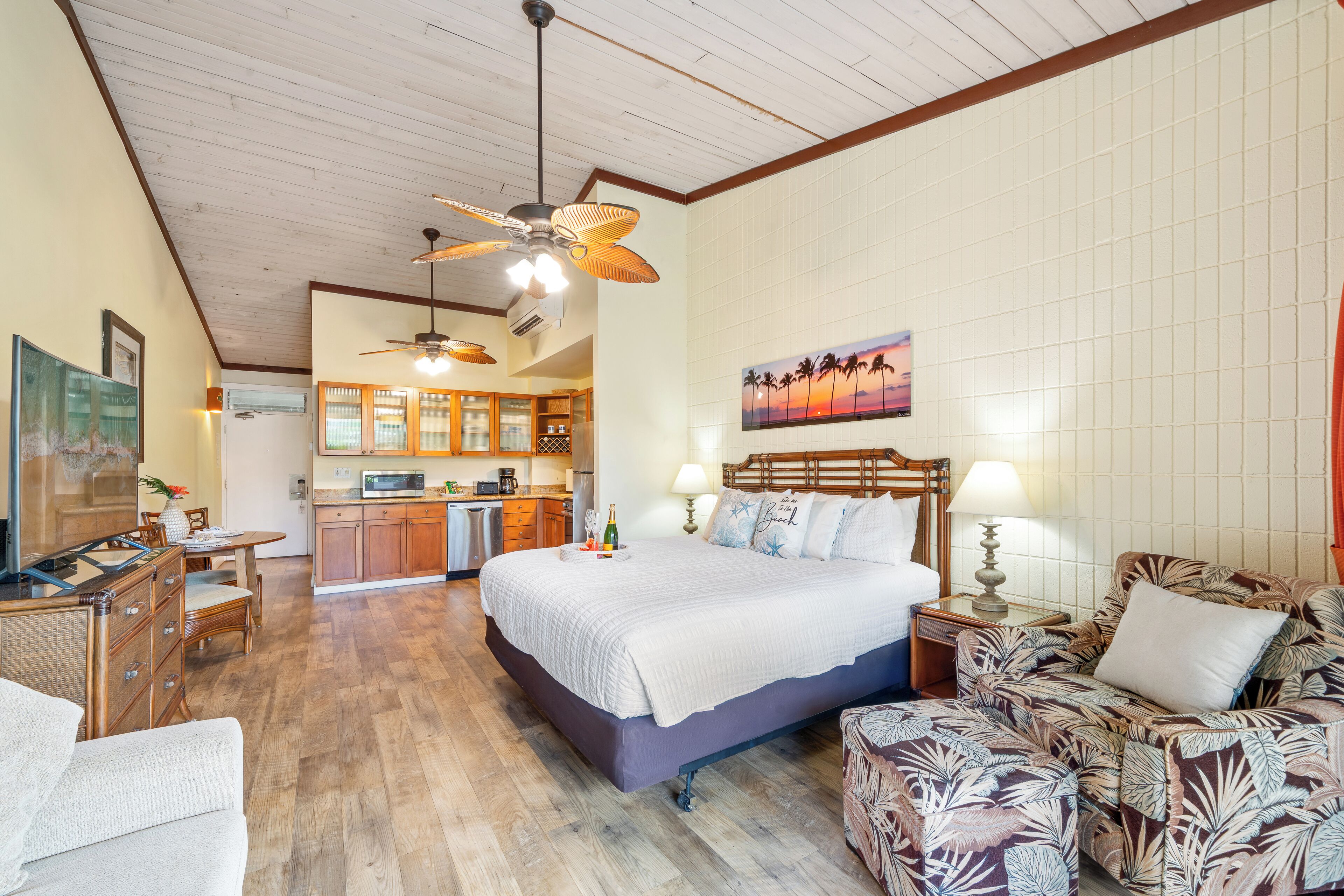 Une chambre spacieuse avec un grand lit, un coin salon avec un canapé, une table à manger et un coin cuisine.