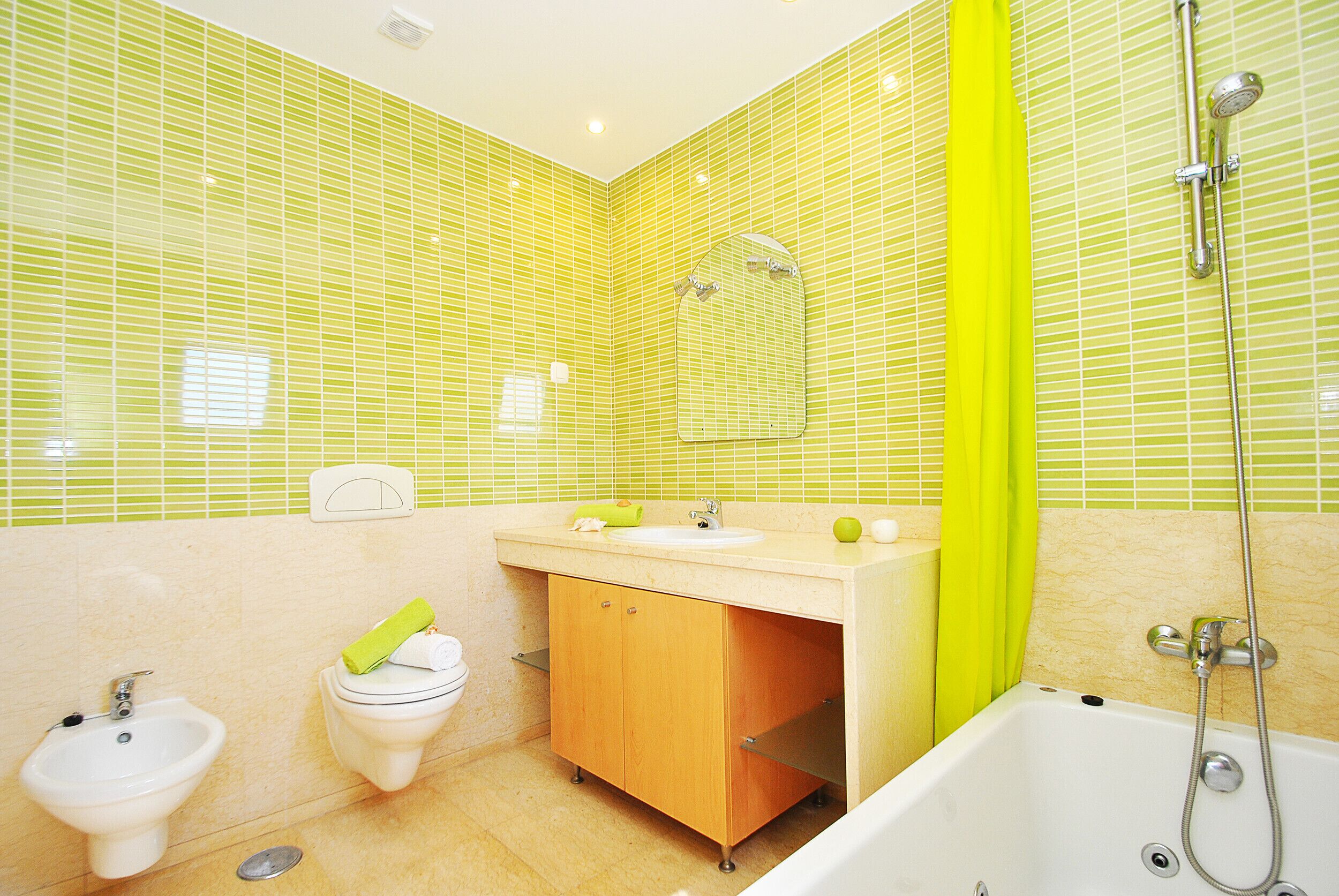 A bathroom with a toilet, bidet, sink, and bathtub.