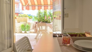 A dining area with a table, chairs, and a glass of fruit. - Soleil Suite in Giardini Naxos (Giardini Naxos)