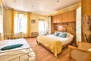 Enjoy a restful stay in this inviting room with a comfortable bed, bedside table, and chair.