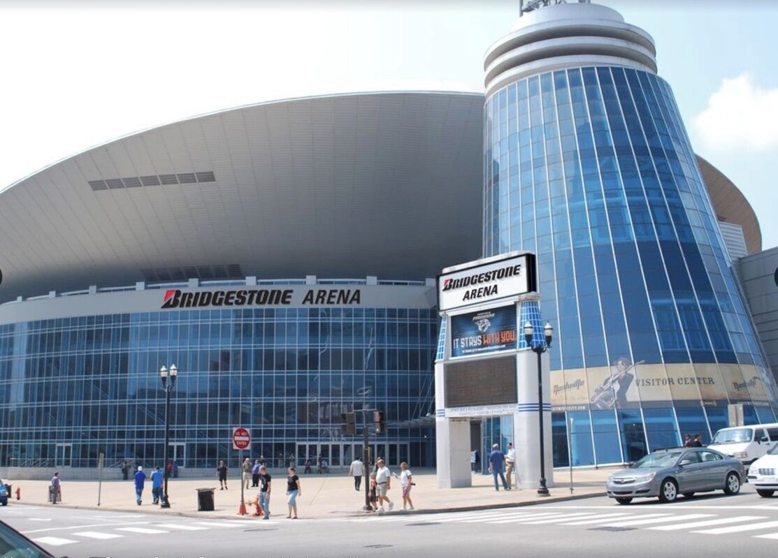 Bridgestone Arena with a large glass facade and a cylindrical section.