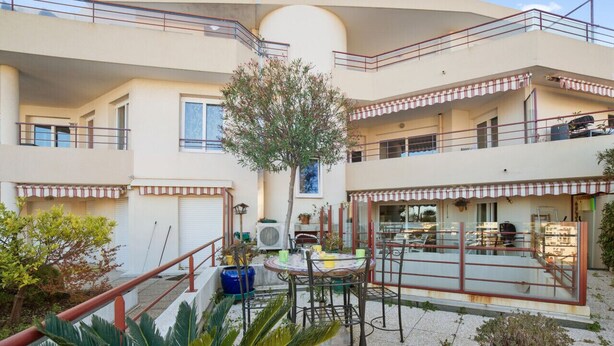 A multi-level residential building with balconies, outdoor seating, and potted plants. - Appartement Lanterne – Welkeys (Nice)
