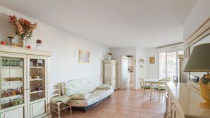 A spacious living area with a sofa, dining table, and cabinets. - Appartement Lanterne – Welkeys (Nice)