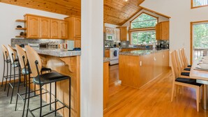 A kitchen with wooden cabinets, a granite countertop, and a central island with seating. - Star Pine_Luxury w/Game Room, Pool Table & HOA Amenities (Hot Tub/Sauna/Gym) (Truckee)