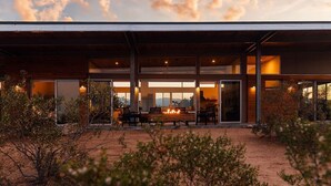 A modern house with a patio, large windows, and a fire pit. - Hawk & Mesa By Homestead Modern (Pioneertown)