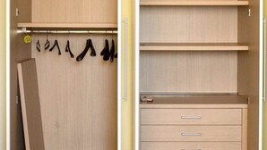 A walk-in closet with open doors, featuring multiple shelves, hanging space, and drawers.