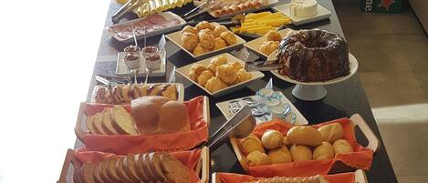 A buffet table with various food items and dining utensils.