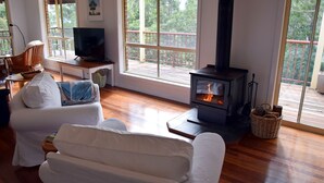 A cozy living room with a fireplace, a television, and comfortable seating. - Arakoon Heights - close to South West Rocks - Bring your own linen (Arakoon)