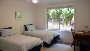 A bedroom with two beds, a desk, and a chair. There is a window with a view of greenery outside. - Arakoon Heights - close to South West Rocks - Bring your own linen (Arakoon)