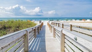 A wooden boardwalk leading to a beach with clear skies and calm waters. - Beautiful 7th floor condo ON THE BEACH (Orange Beach)