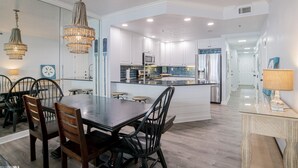 A modern kitchen with white cabinets, a central island, and pendant lighting. - Beautiful 7th floor condo ON THE BEACH (Orange Beach)