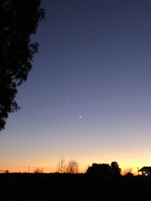 Un ciel nocturne dégagé, avec un croissant de lune et une étoile brillante.