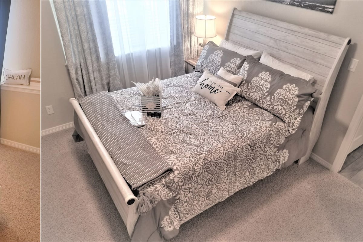 A bedroom with a bed, a nightstand, a lamp, and a view of a snowy landscape.