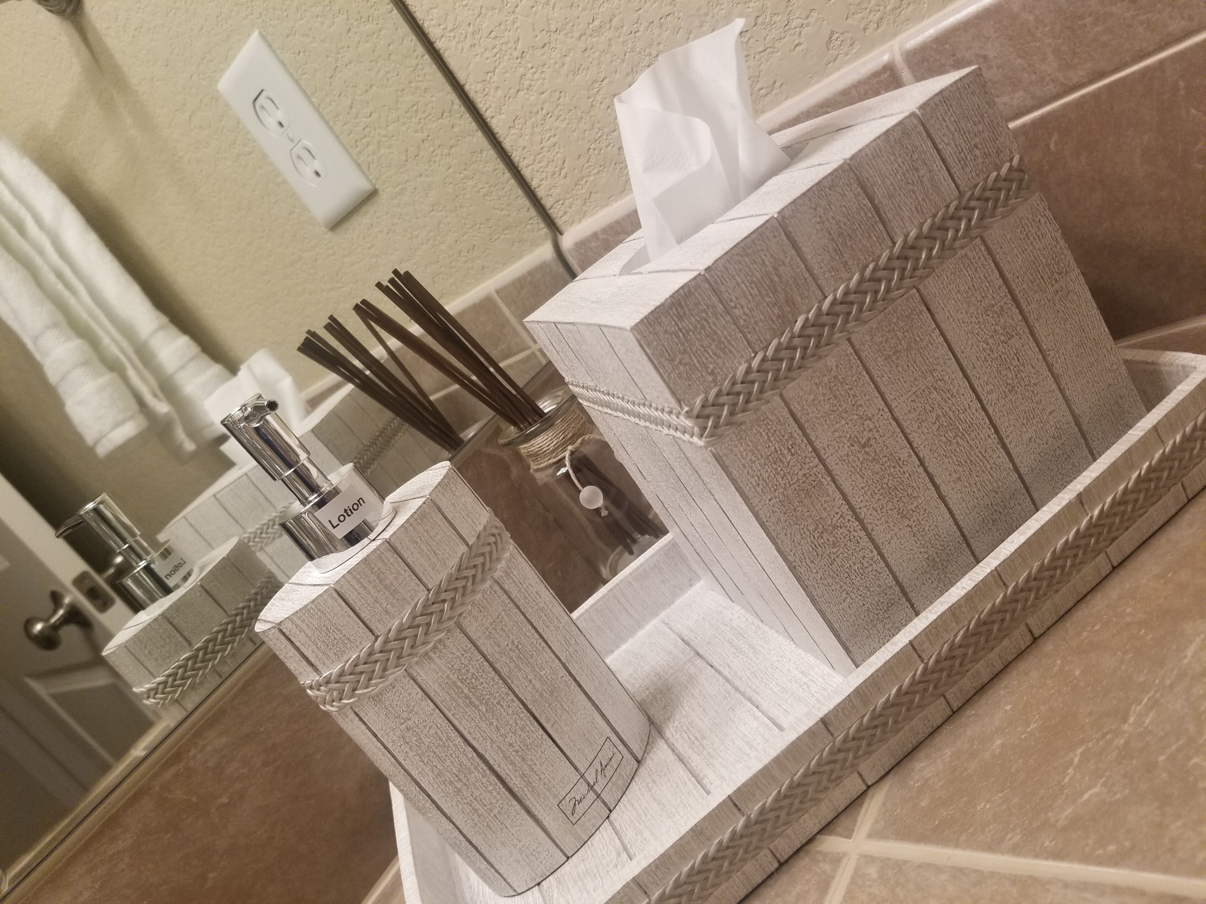 A bathroom with a mirror, a soap dispenser, and a tissue holder.