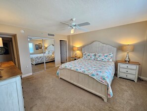 A bedroom with a bed, two bedside tables, a ceiling fan, and a mirror. - Sandy Key 721: 3 BR/2 BA On-Site Rental Office, Perdido Key Beachfront Condo, Sleeps 8 (Pensacola)