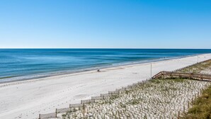 En strand med en träpromenad och ett sandområde.