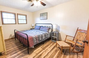 A bedroom with a bed, bedside lamps, a chair, and a wooden floor. - Can't beat this view! 3 pools, pickleball, next to zip lining, hiking & downtown (Gatlinburg)