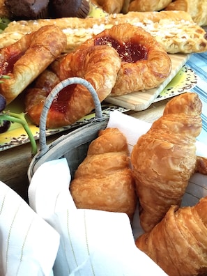 A variety of pastries, including croissants and a pastry with a handle, displayed on a wooden board. - The Kenwood Gables B&B (St. Petersburg)