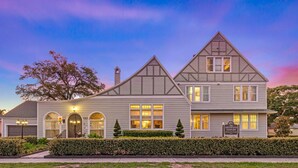 A two-story house with a garage, multiple windows, and a well-maintained front yard. - The Kenwood Gables B&B (St. Petersburg)