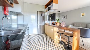 Eine moderne Küche mit Einbauofen, Edelstahl-Spüle und einer Holztresenplatte.