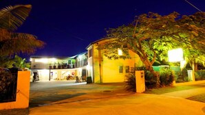 A two-story building with a curved facade, a balcony on the upper floor, and a well-lit entrance. - Caloundra Backpackers - Hostel (Caloundra)