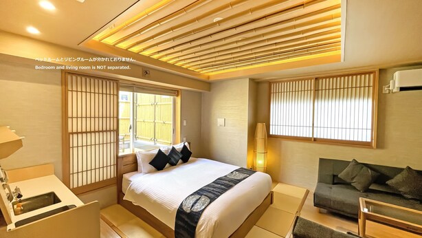 Ein modernes Hotelzimmer mit Bett, Nachttisch und einer Couch.