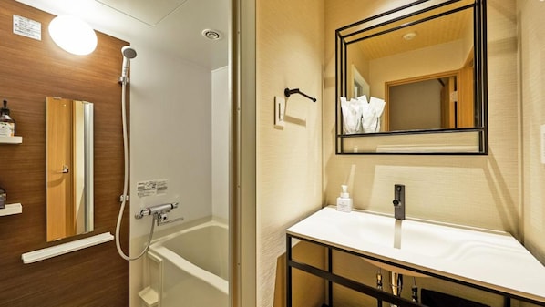 A modern bathroom with a bathtub, a sink, and a mirror. - Stay SAKURA Tokyo Shinjuku Hyaku kura (Tokyo)