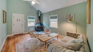 Una sala acogedora con chimenea, dos sillones de mimbre, un sofá y una mesa de centro.