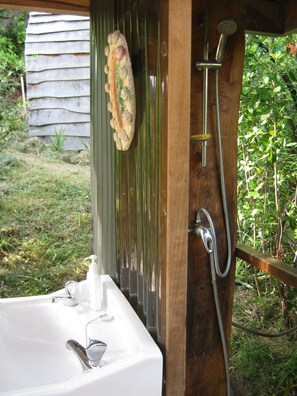 Une salle de bain avec un lavabo, une douche et un objet décoratif accroché au mur.