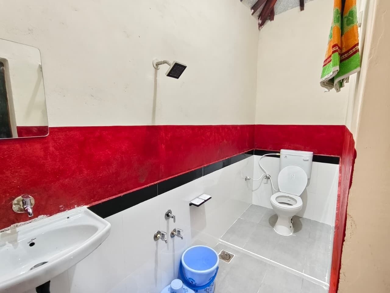 A small bathroom with a white sink, a toilet, and a shower.