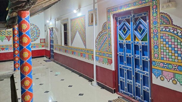 A corridor with colorful wall decorations and a blue door.