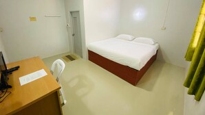 Una habitación pequeña y limpia con una cama individual, un escritorio y una silla.
