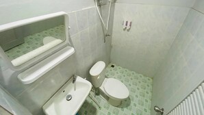 Un baño pequeño con inodoro, lavamanos y ducha.
