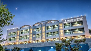 Un hotel de diverses plantes amb un cartell ben visible que diu 'KEY WEST', amb balcons i un disseny arquitectònic modern.