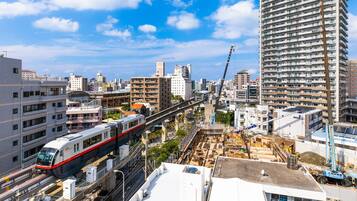 Un tren de alta velocidad atraviesa una ciudad con edificios modernos y zonas de construcción.