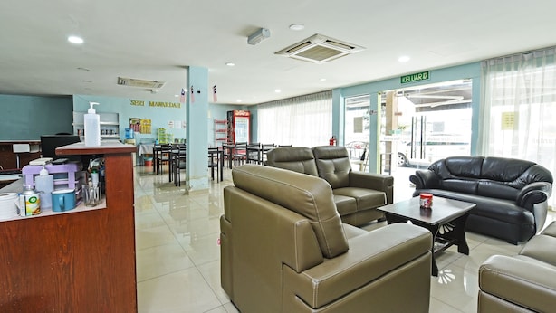 A hotel lobby with leather sofas, a reception desk, and a dining area. - Seri Mawardah Hotel (Malacca City)