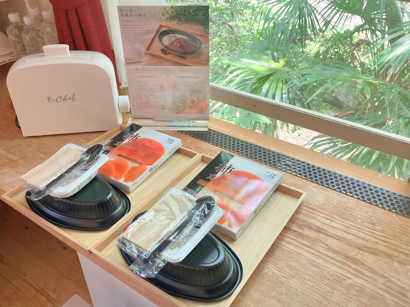 A wooden counter with a white appliance labeled 'Chef' and two trays with packaged food items.