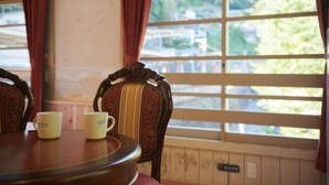 A dining table with two yellow mugs and a wooden chair with a striped backrest. - The Railway Hotel Koyasan Pilgrimage Railway (Kudoyama)
