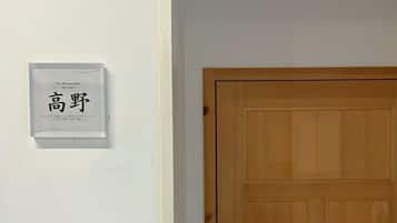 A white wall with a framed sign that reads 'The Railway Hotel' and a wooden door.